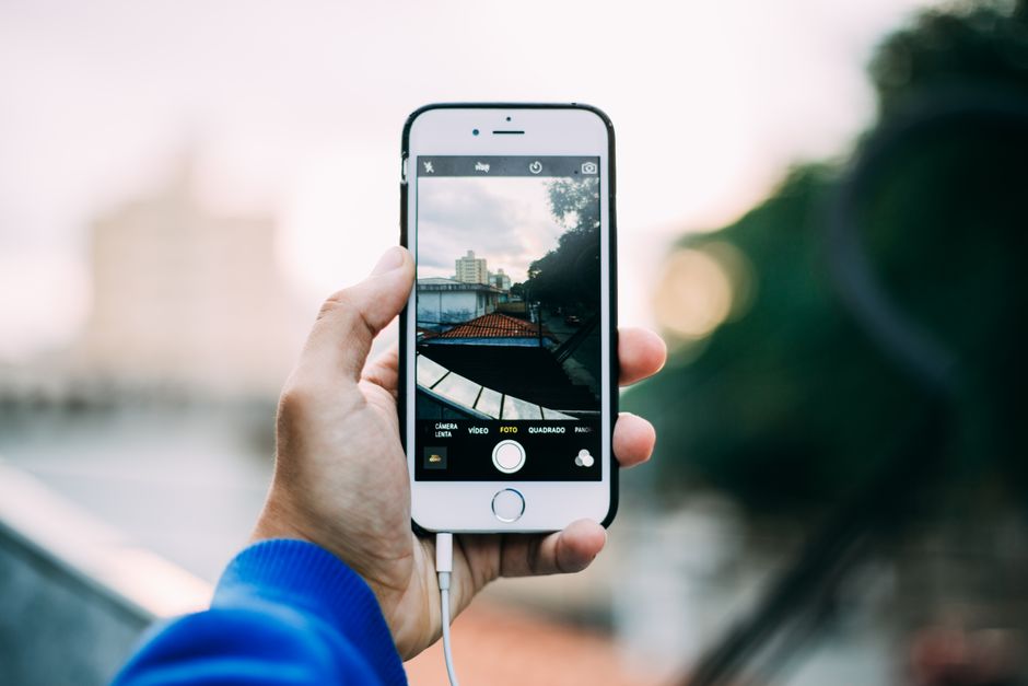 Ruka koja drži pametni telefon i fotografira gradski krajolik